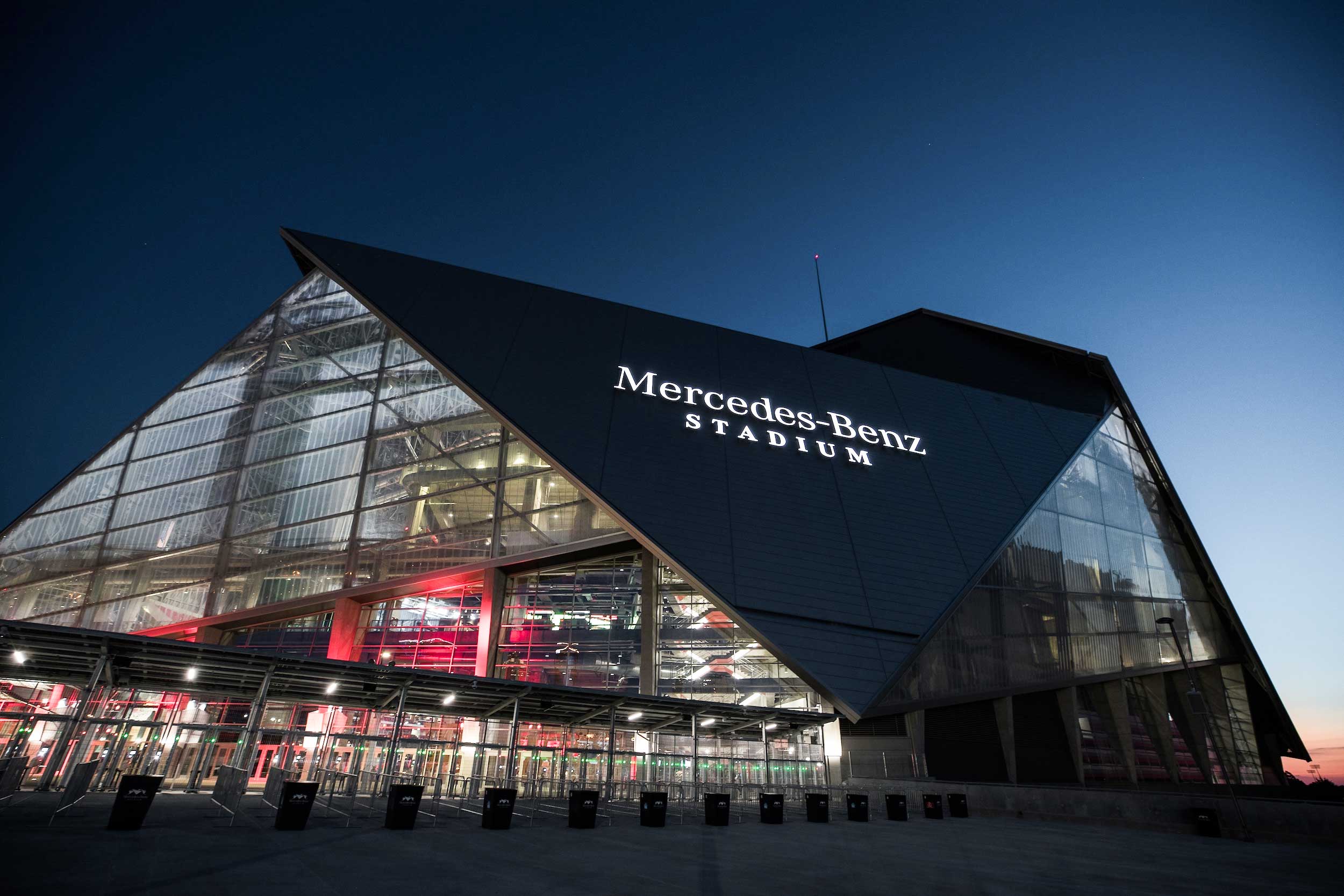 Exterior view of Mercedes-Benz Stadium in Atlanta at night, illuminated for World Cup 2026 events, showing stadium lights and modern architecture.