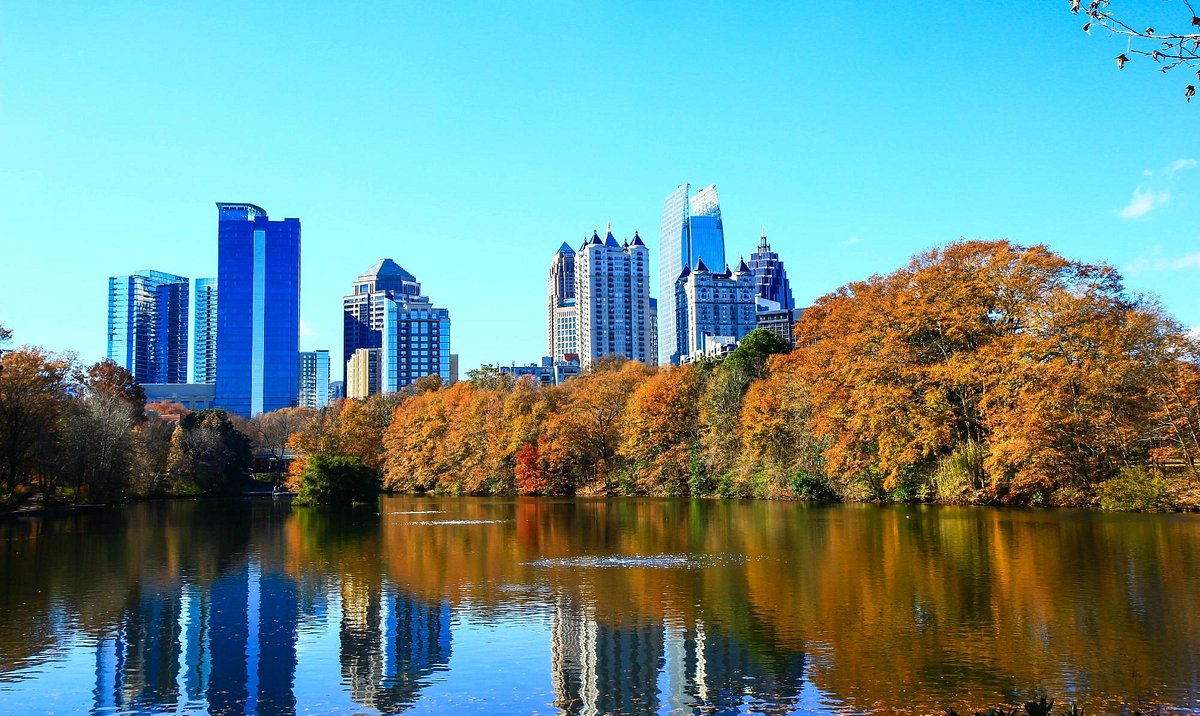 Piedmont Park in Atlanta, Georgia, with open green space and city skyline in the background following a nighttime shooting incident.