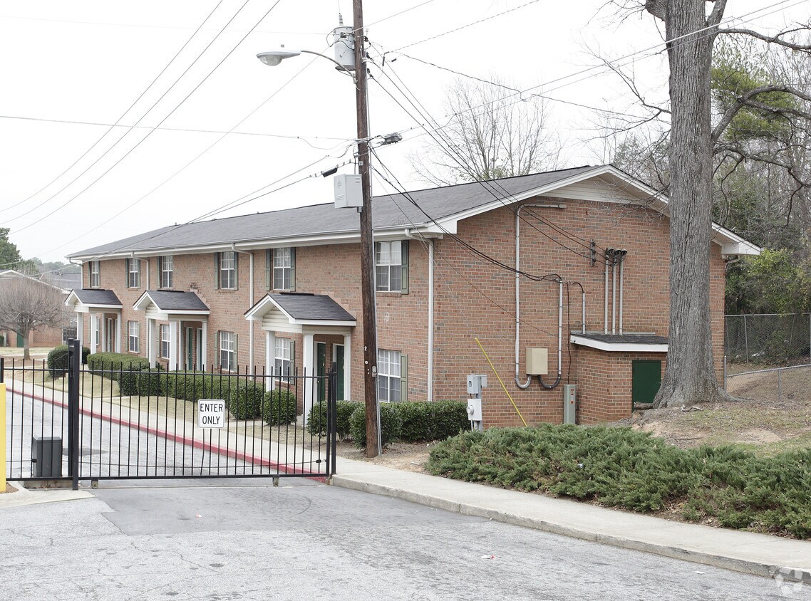 The gated entrance and brick apartment buildings at Colonial Square Apartments on Old Hapeville Road in Atlanta, Georgia.