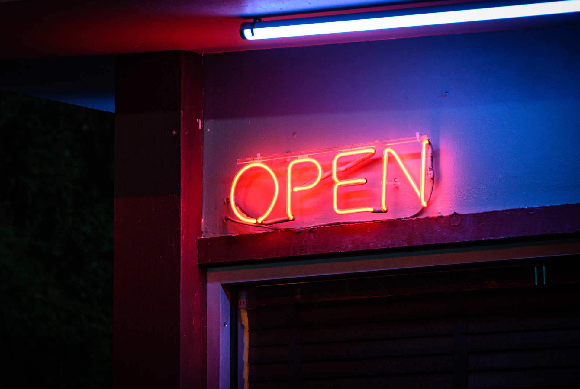 neon open sign on a wall in a dark lit room.